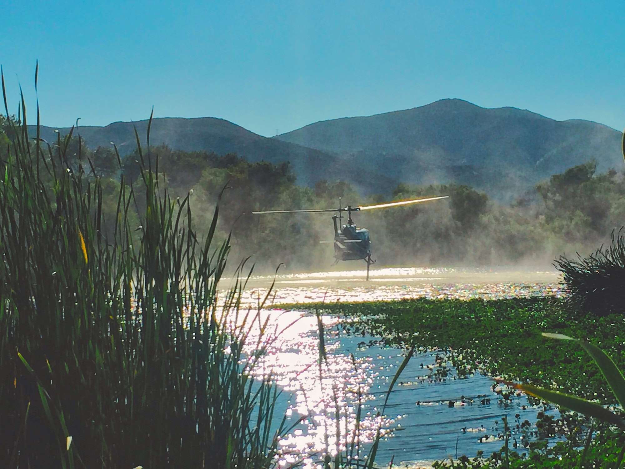 Emergency helicopter utilizing water from a lake to fight fires.