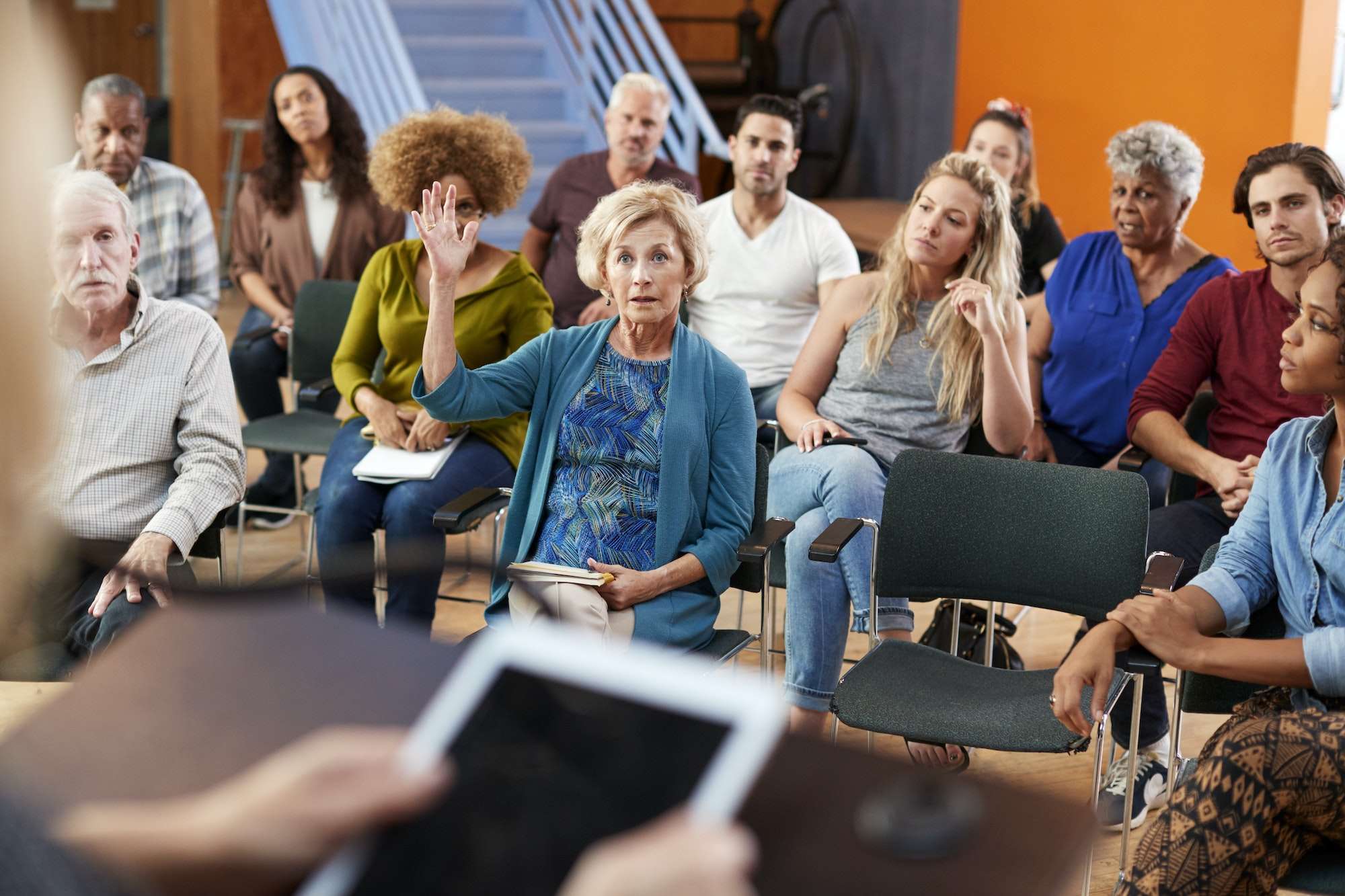 Woman Asking Question At Group Neighborhood Meeting In Community Center